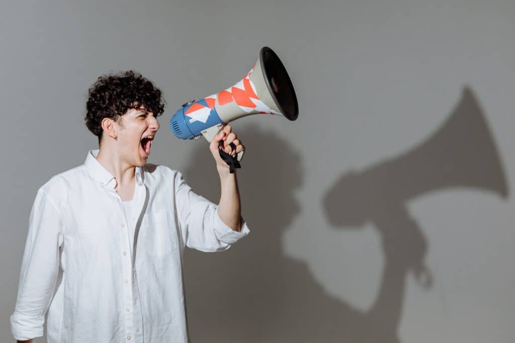 Man shouting through megaphone to no audience.