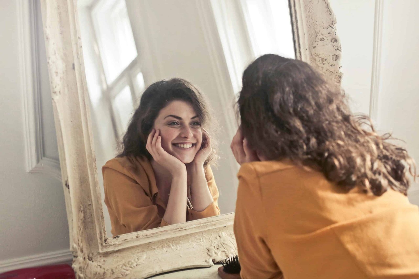 Lady smiling at herself in the mirror