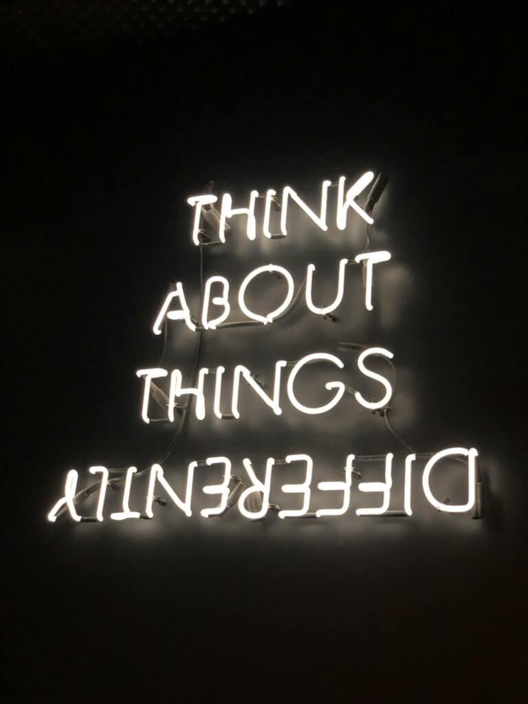 Sign saying "Think about things differently" with the word Differently written upside down.